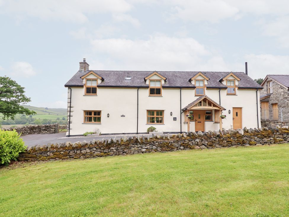 A house with a front garden and stone wall at Ty Gwyn Llangwm near Bala