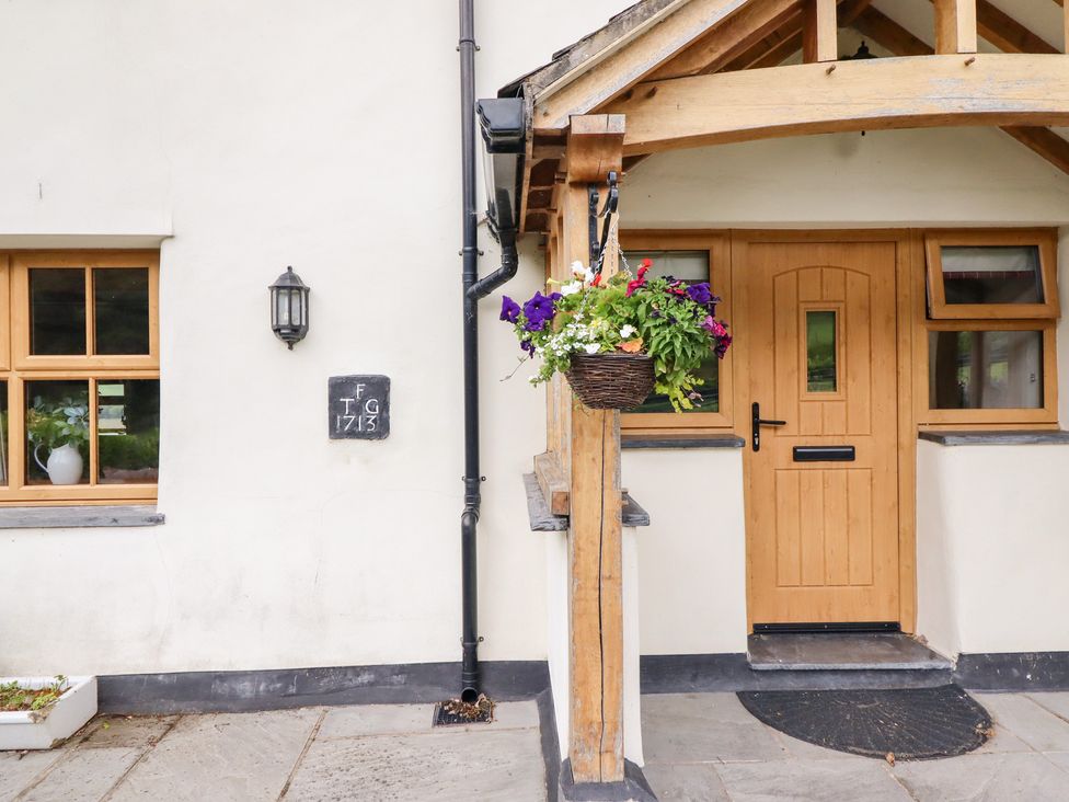 An entrance with a wooden door and window at Ty Gwyn in Llangwm near Bala