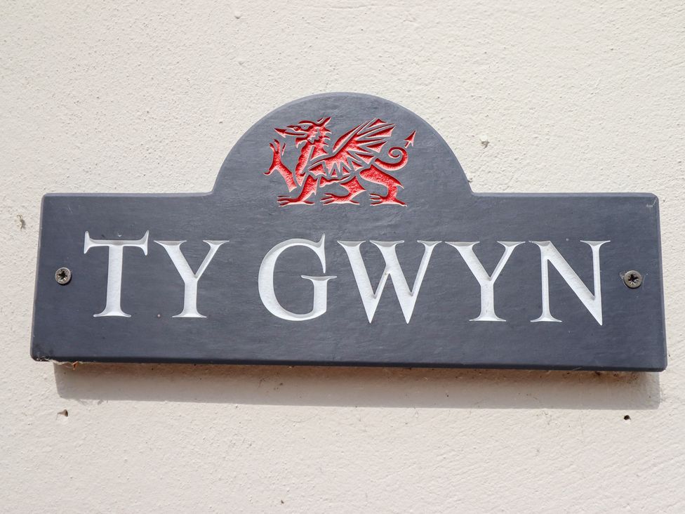 A nameplate with TY GWYN and a dragon crest at Ty Gwyn in Llangwm near Bala