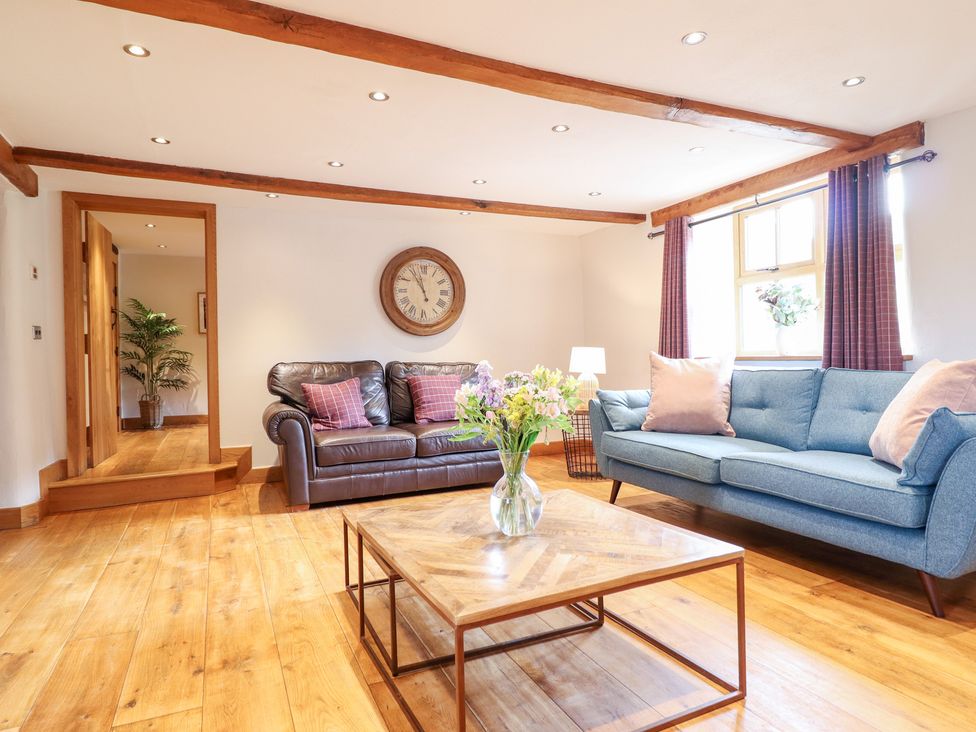 A living room with a sofa and coffee table at Ty Gwyn in Llangwm near Bala