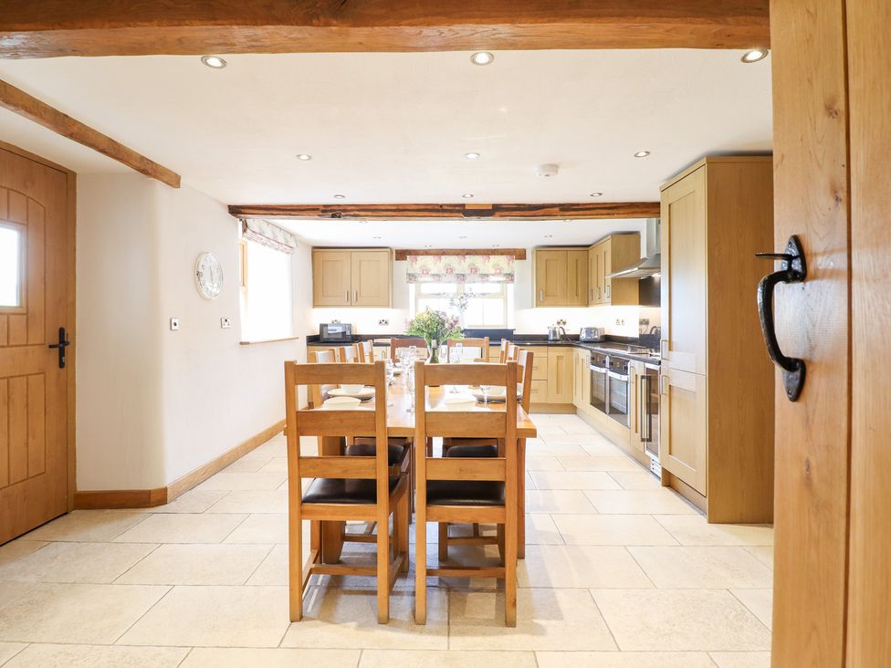A kitchen with a dining table and chairs at Ty Gwyn in Llangwm near Bala