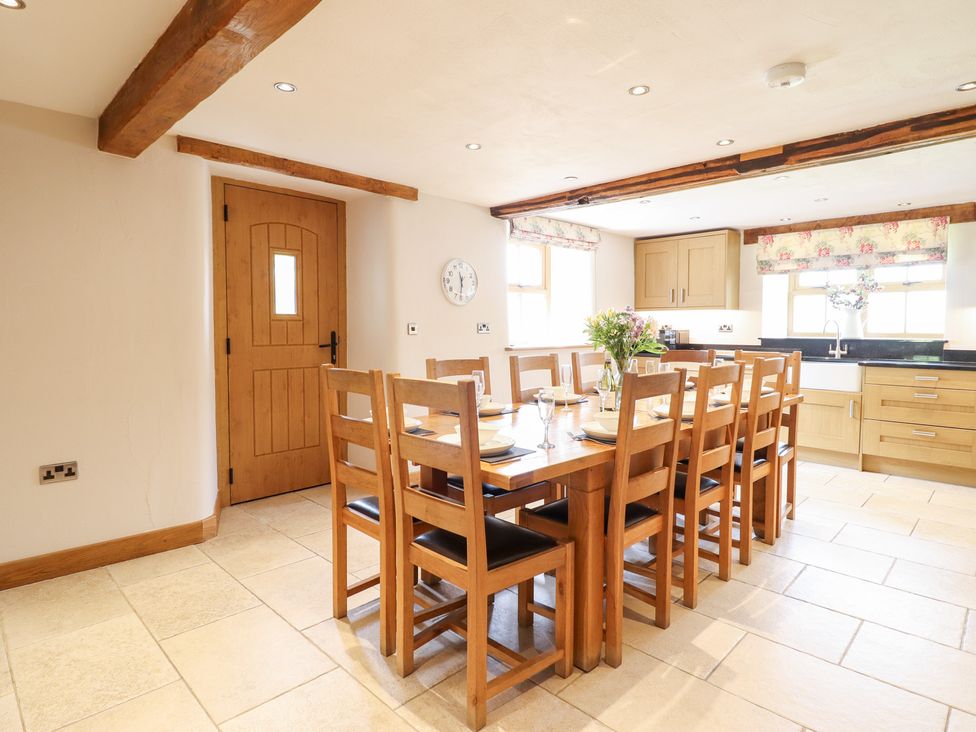 A dining room with a large table and chairs at Ty Gwyn in Llangwm near Bala