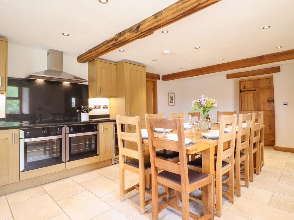A kitchen with a dining table and chairs at Ty Gwyn in Llangwm near Bala