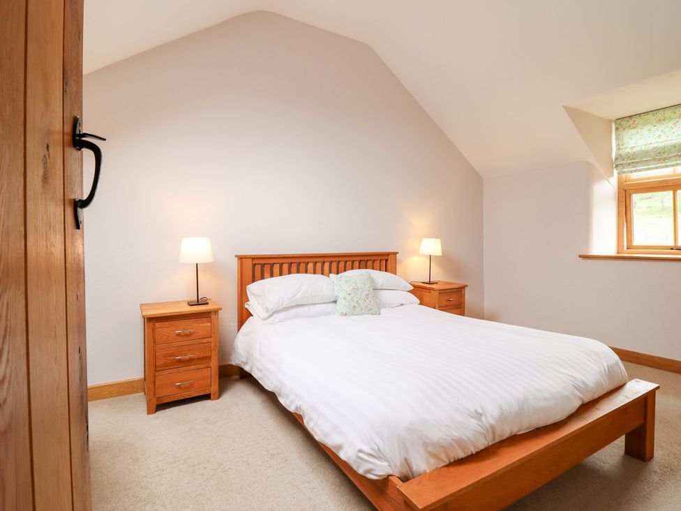 A bedroom with a bed and side tables at Ty Gwyn in Llangwm near Bala