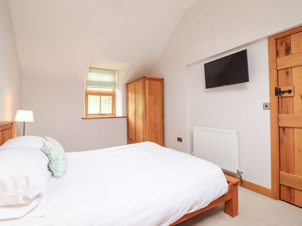 A bedroom with a bed and wardrobe at Ty Gwyn in Llangwm near Bala