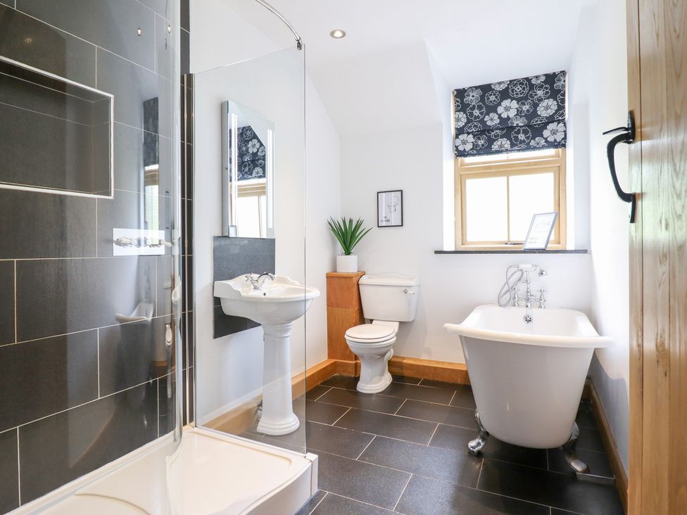 A bathroom with a shower, sink, toilet and bathtub at Ty Gwyn in Llangwm near Bala