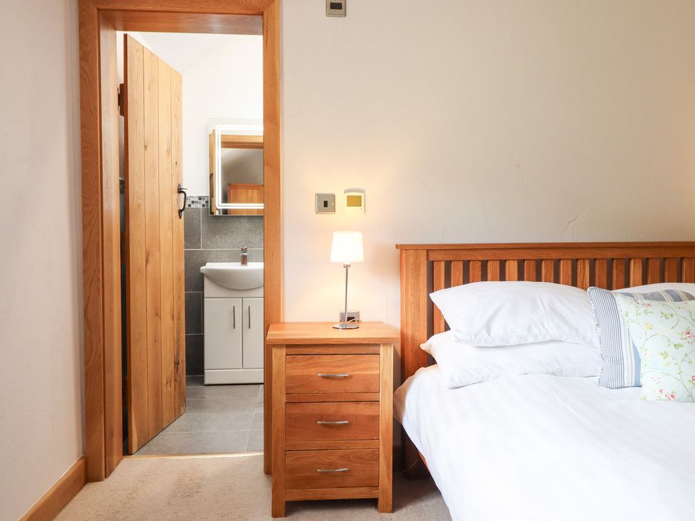 A bedroom with a bed and nightstand at Ty Gwyn in Llangwm near Bala