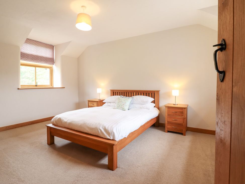 A bedroom with a bed and nightstands at Ty Gwyn in Llangwm near Bala
