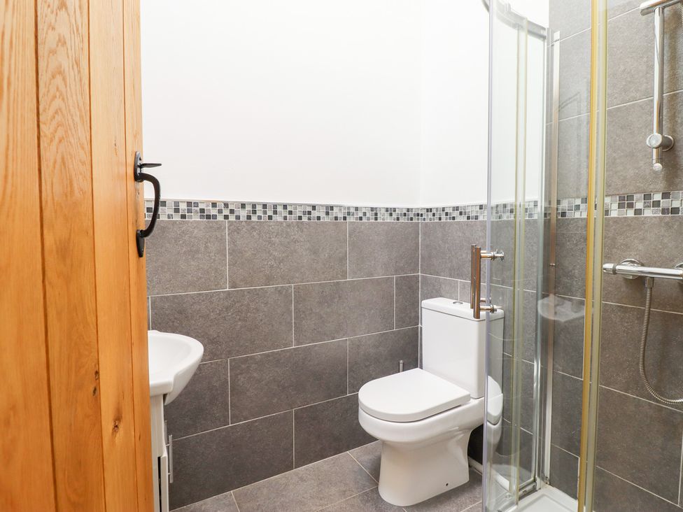 A bathroom with a shower, toilet, and sink at Ty Gwyn in Llangwm near Bala