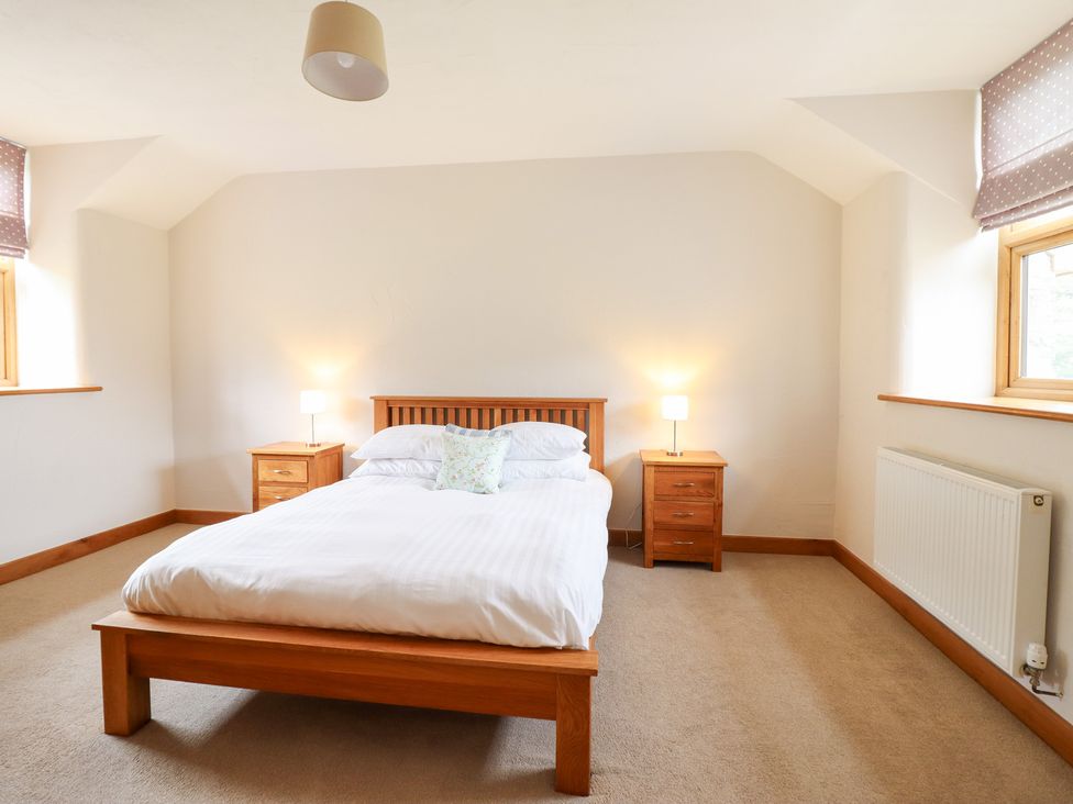 A bedroom with a bed and nightstands at Ty Gwyn in Llangwm near Bala
