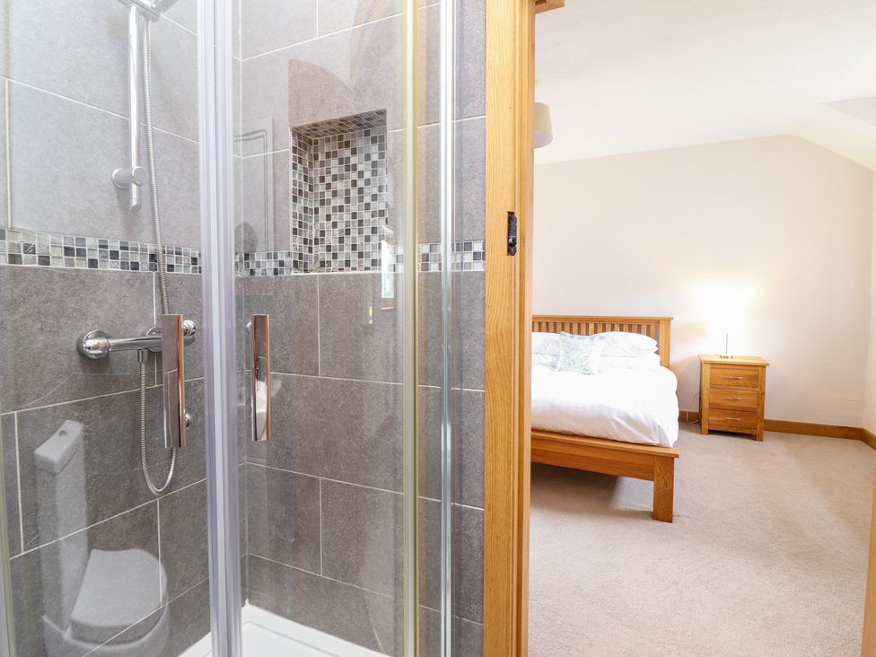 A bathroom with a shower and a view of a bedroom at Ty Gwyn Llangwm near Bala