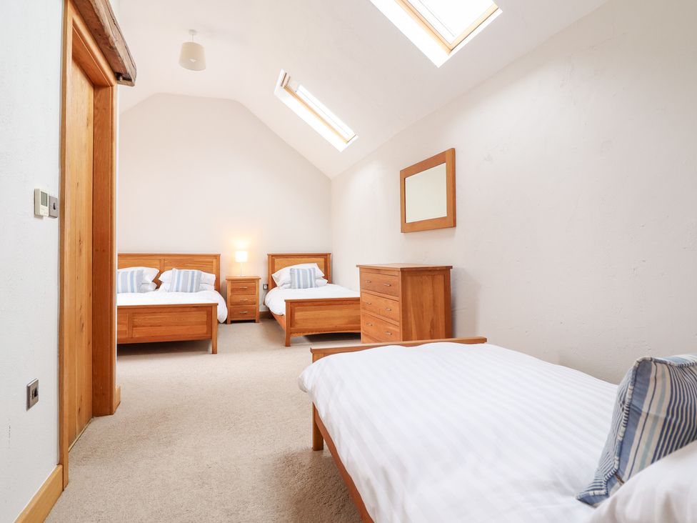 A bedroom with two beds and a dresser at Ty Gwyn in Llangwm near Bala