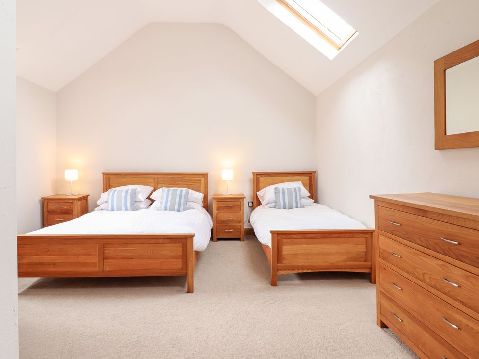 A bedroom with two beds and a dresser at Ty Gwyn in Llangwm near Bala