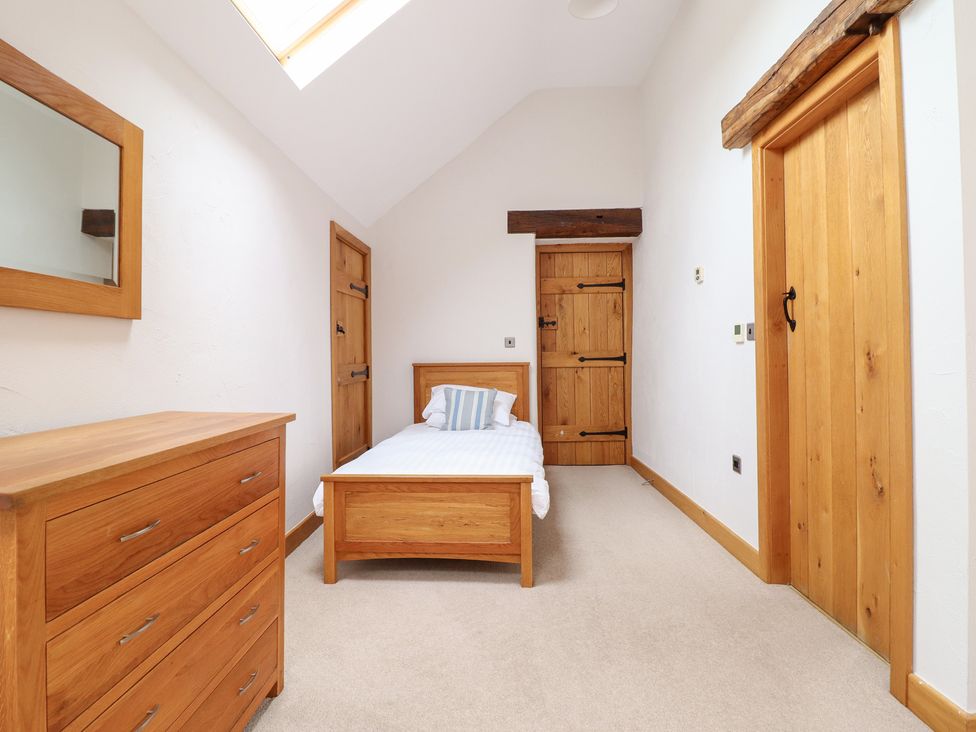 A bedroom with a bed and a mirror at Ty Gwyn in Llangwm near Bala