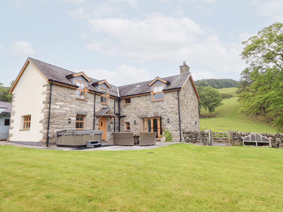 A house with a hot tub and outdoor seating at Ty Gwyn Llangwm near Bala