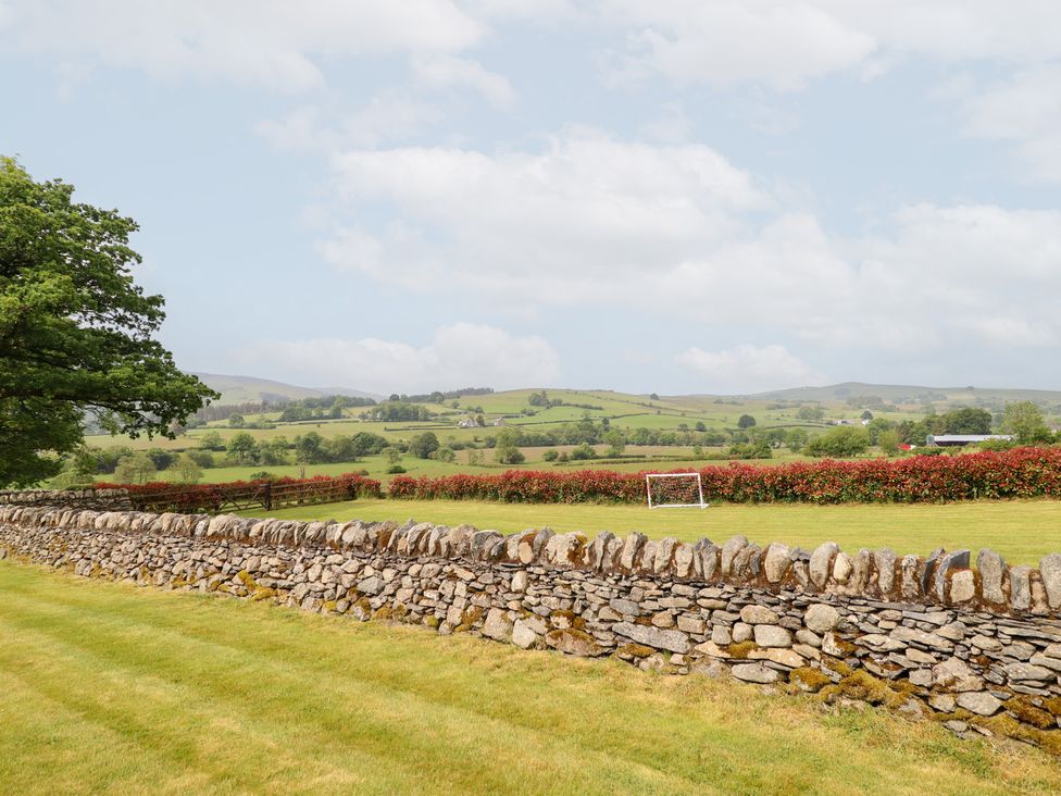 An outdoor photo of a landscape with a stone wall and a goal post at Ty Gwyn in Llangwm near Bala
