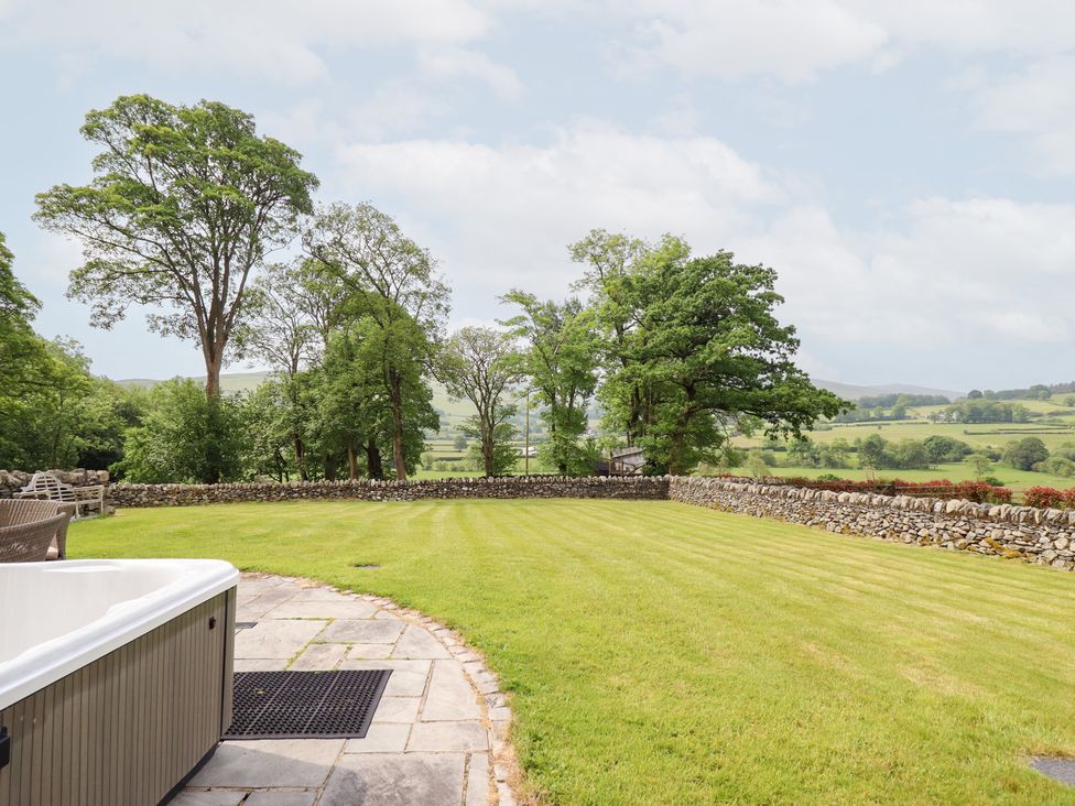 An outdoor area with a hot tub and grass at Ty Gwyn in Llangwm near Bala