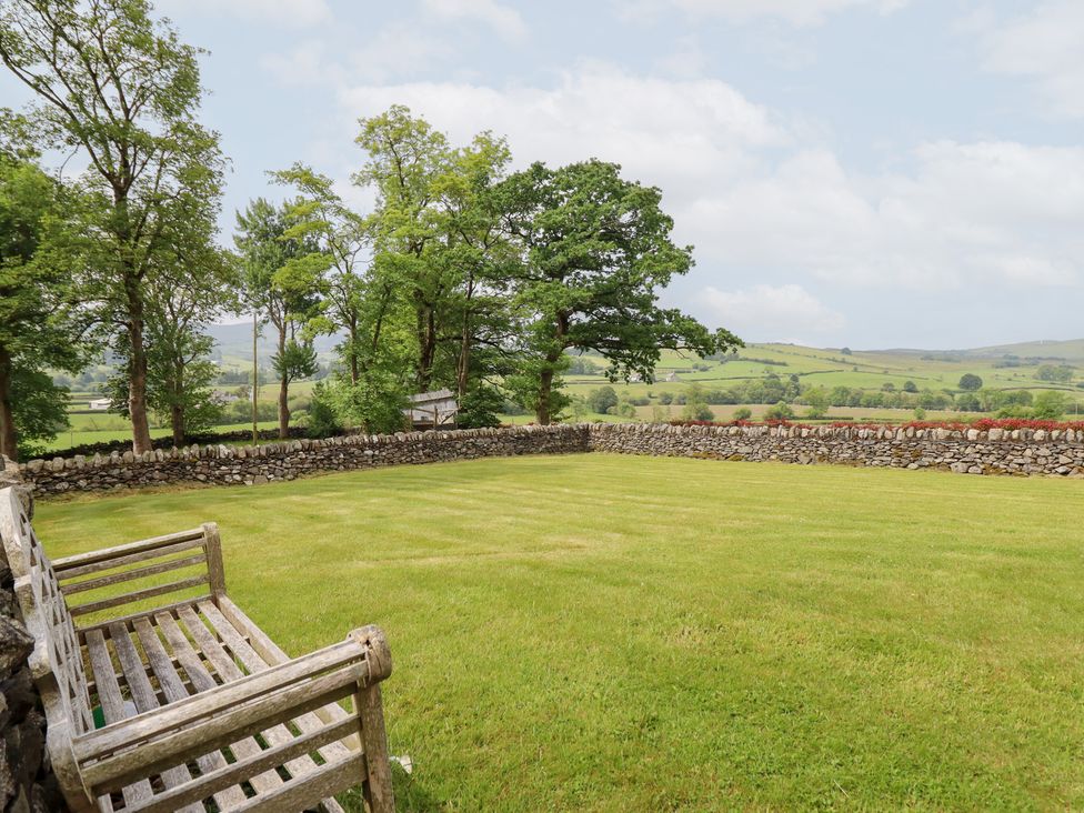 A garden with grass and trees at Ty Gwyn in Llangwm near Bala