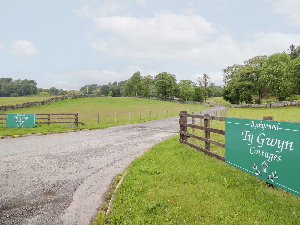 An entrance road with a sign for Ty Gwyn Cottages located in Llangwm near Bala