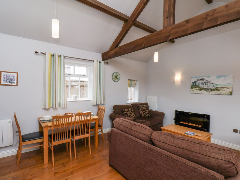 A living room with a dining area and sofa at Beacon in Gerrick near Moorsholm