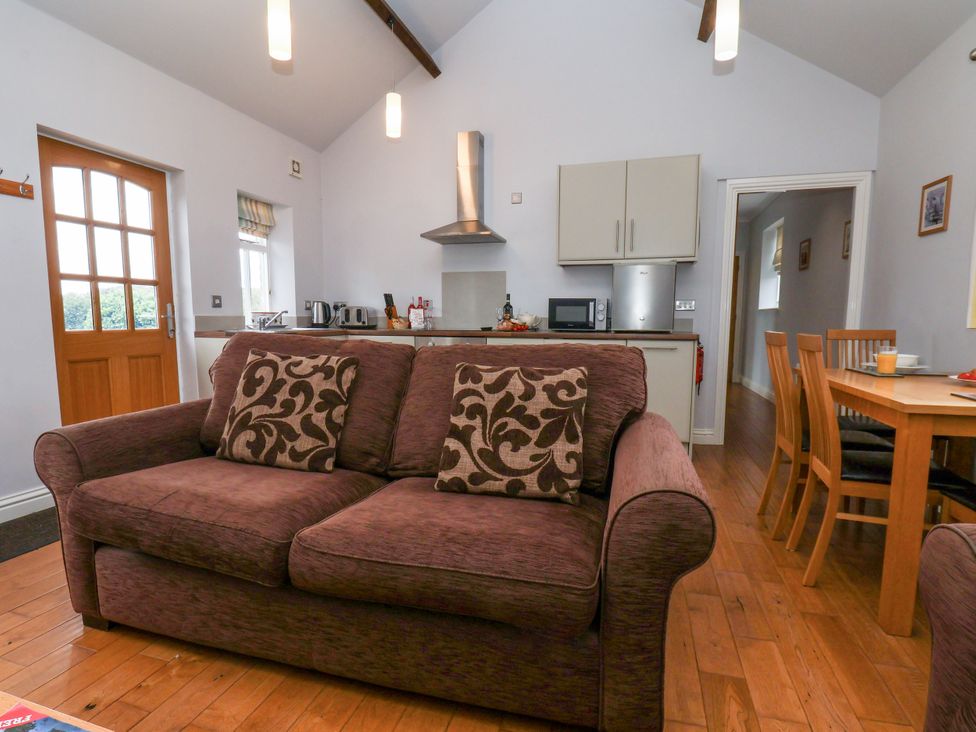 A living room with a sofa and dining area at Beacon in Gerrick near Moorsholm