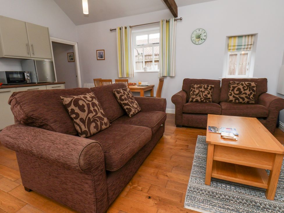 A living room with a sofa and dining area at Beacon in Gerrick near Moorsholm