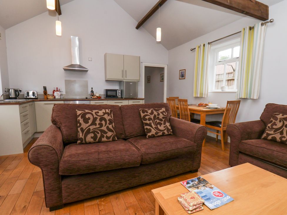 A living room with a sofa and dining area at Beacon Gerrick near Moorsholm