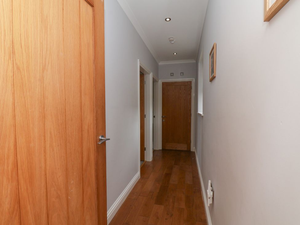 A hallway with wooden doors and light fixtures at Beacon in Gerrick near Moorsholm