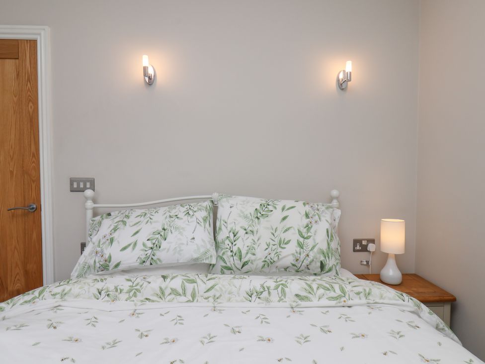 A bedroom with a bed and bedside lamp at Beacon in Gerrick near Moorsholm