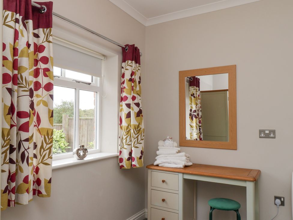 A bathroom with a vanity table and mirror at Beacon in Gerrick near Moorsholm