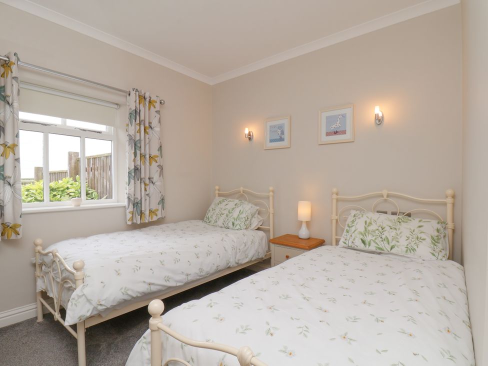 A bedroom with two beds and a window at Beacon in Gerrick near Moorsholm