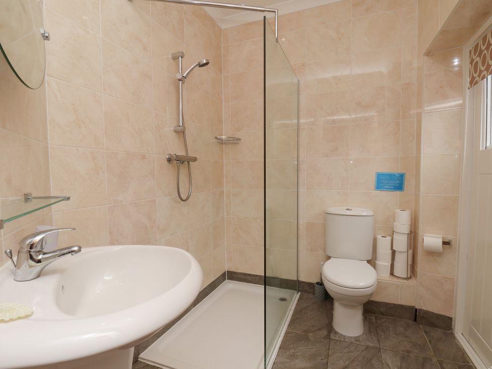 A bathroom with a shower, sink, and toilet at Beacon in Gerrick near Moorsholm