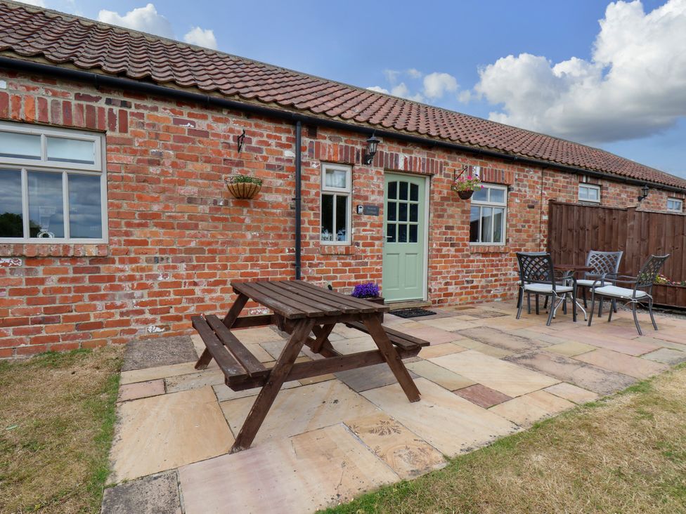 An outdoor patio area with a picnic table and chairs at Beacon in Gerrick near Moorsholm