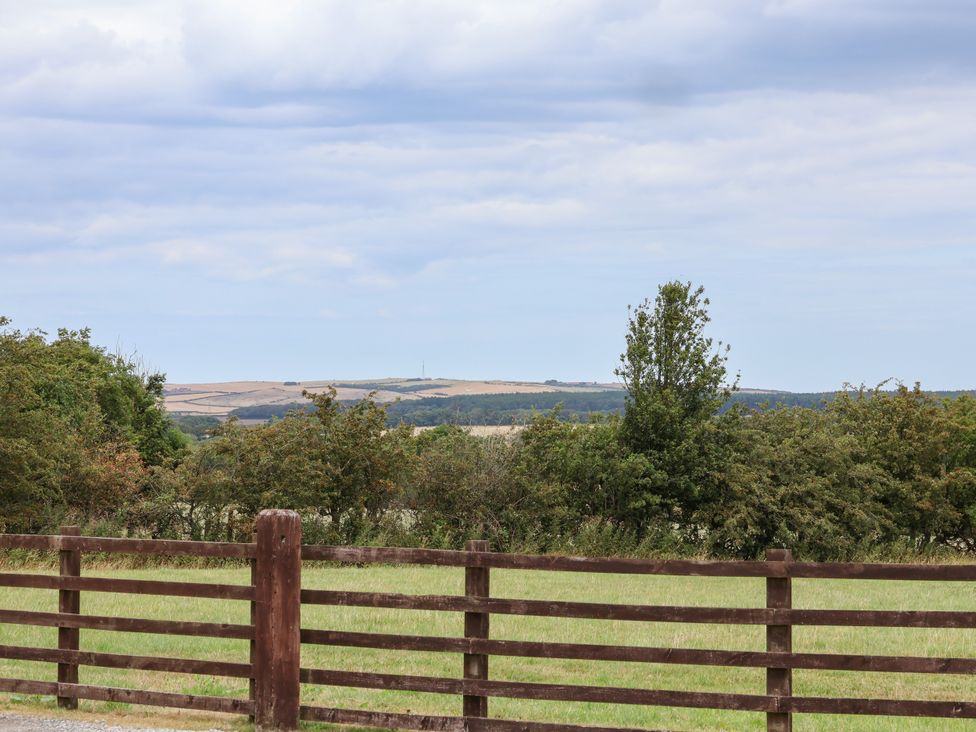 A view of hills and trees with a fence in the foreground at Beacon Gerrick near Moorsholm