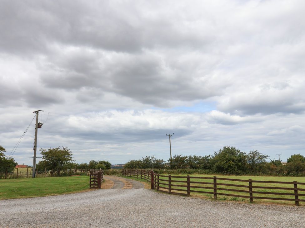An outdoor view with a gravel road and wooden fence at Beacon in Gerrick near Moorsholm