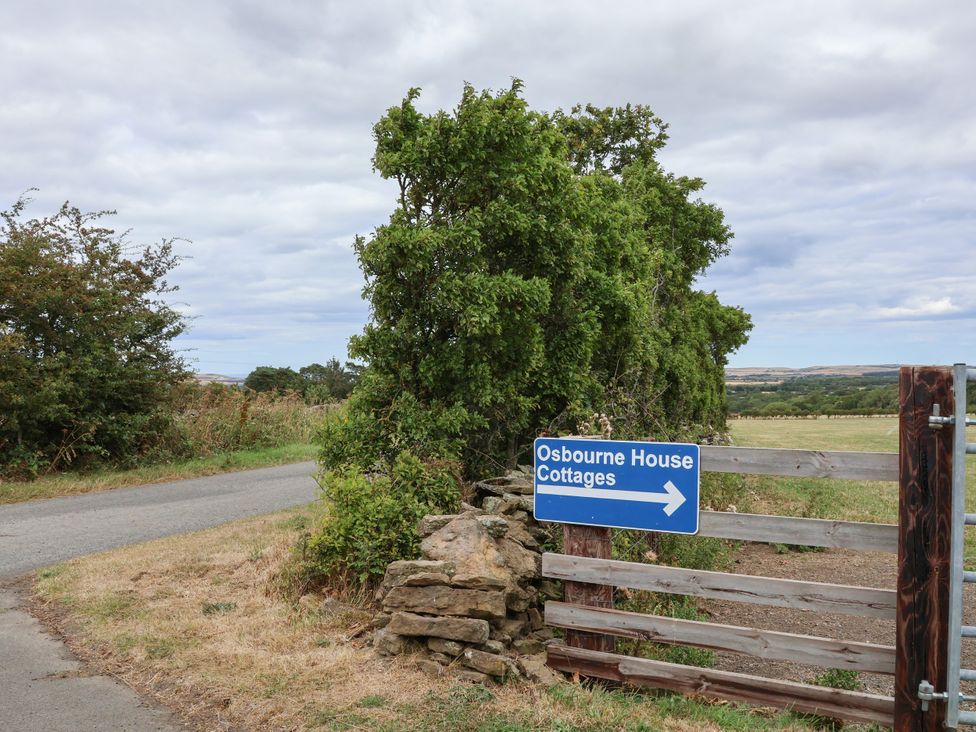 A sign directing to Osbourne House Cottages near a road in Gerrick near Moorsholm