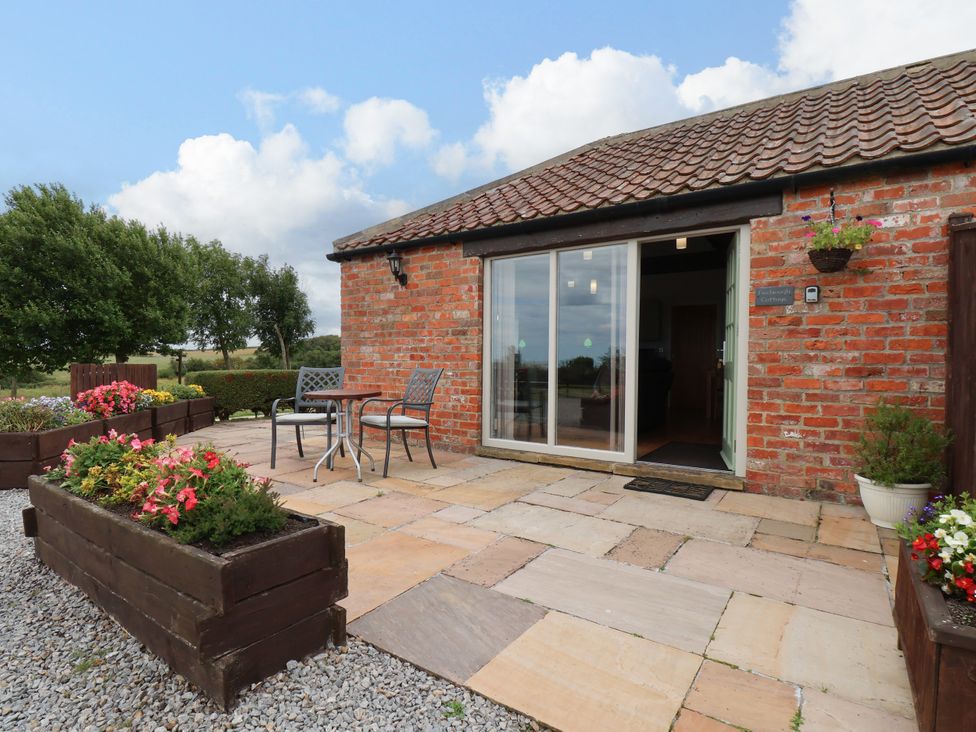 An outdoor seating area with a table and chairs at Freeborough Gerrick near Moorsholm
