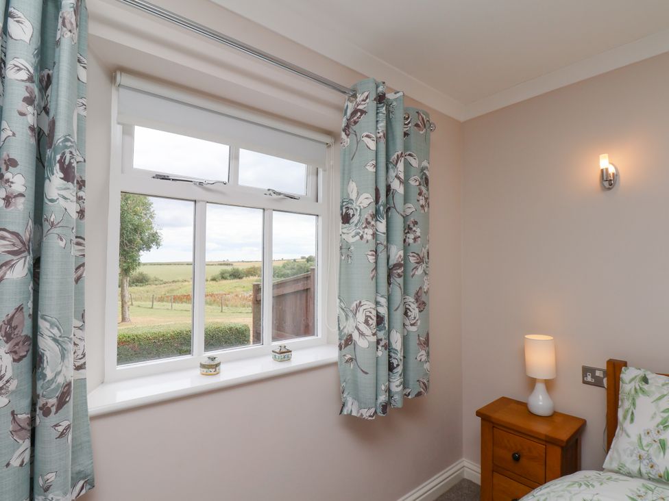 A bedroom with window and curtains at Freeborough Gerrick near Moorsholm