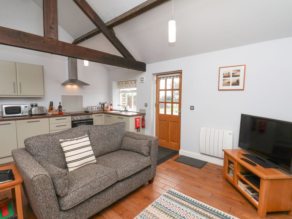 A living room with a sofa and kitchen area at Blakey in Gerrick near Moorsholm
