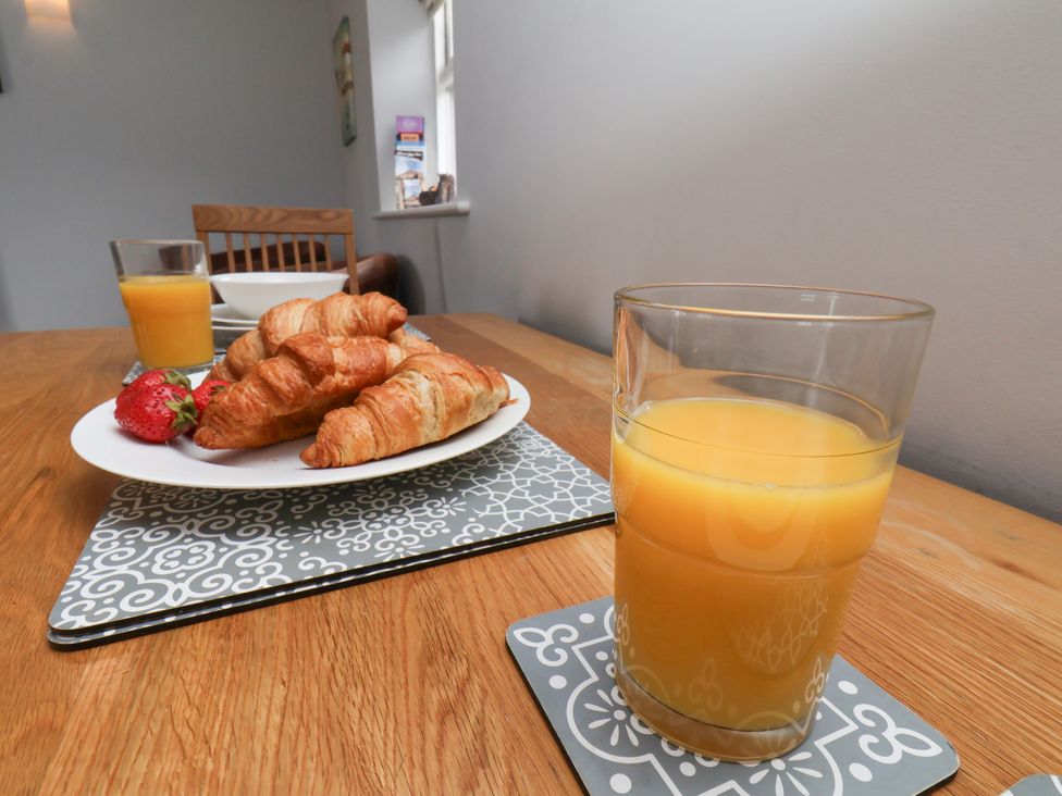 A dining room with croissants, strawberry, and orange juice at Blakey in Gerrick near Moorsholm