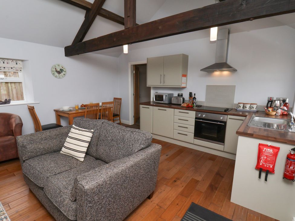 A living room with a sofa and kitchen area at Blakey in Gerrick near Moorsholm