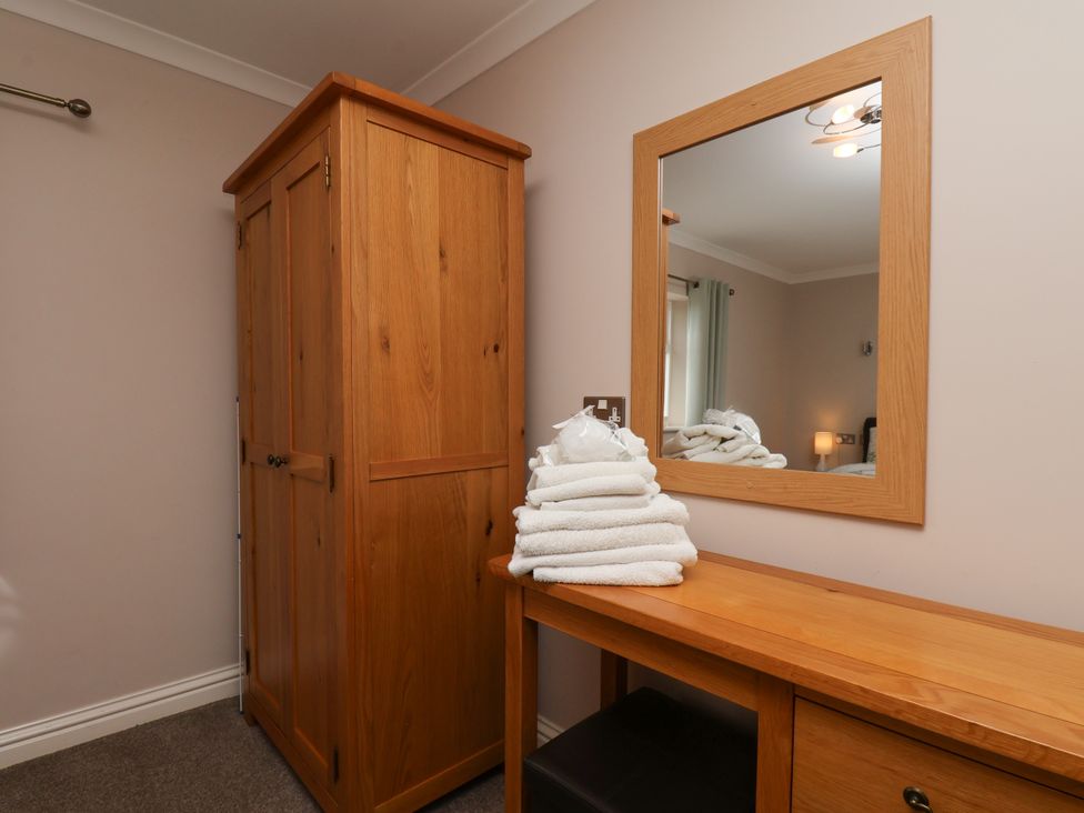A bedroom with a wardrobe and stacked towels at Blakey in Gerrick near Moorsholm