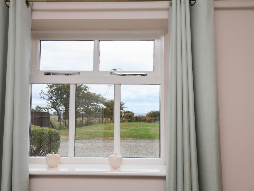A window with curtains and vases on the sill at Blakey Gerrick near Moorsholm