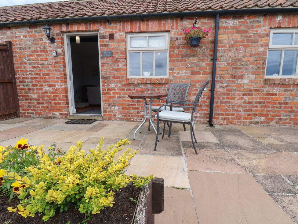 An outdoor seating area with a table and chairs at Blakey in Gerrick near Moorsholm