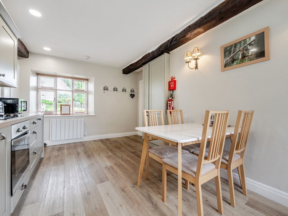 A kitchen with a dining table and chairs at Dove Cottage at the Graythwaite Estate near Hawkshead