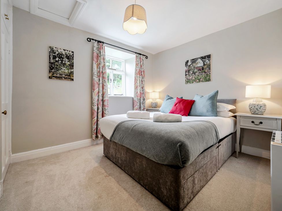 A bedroom with a bed and bedside lamps at Dove Cottage at the Graythwaite Estate near Hawkshead