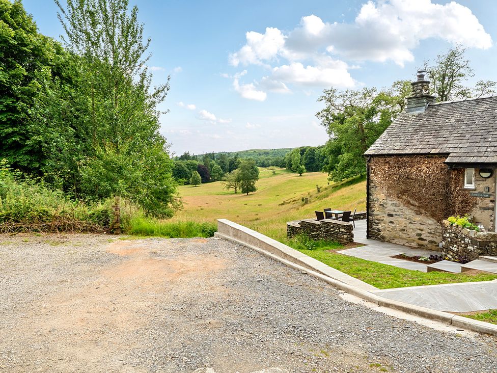A cottage with outdoor seating and a gravel path at Dove Cottage at the Graythwaite Estate near Hawkshead