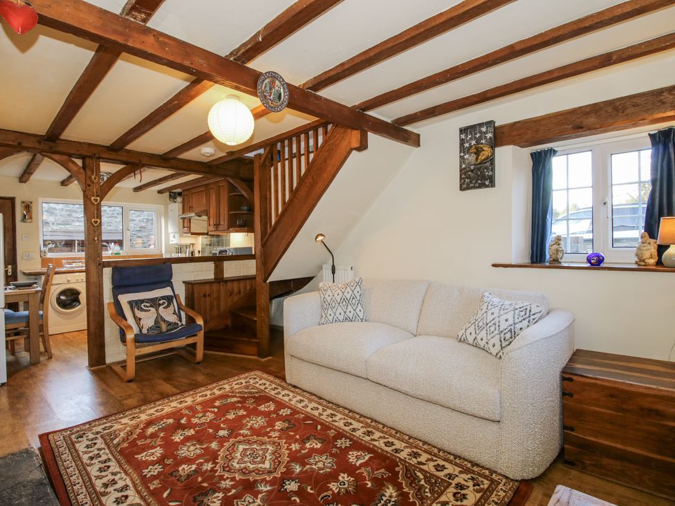 A living room with a sofa and kitchen area at Marigold Cottage in Clun near Bishop's Castle