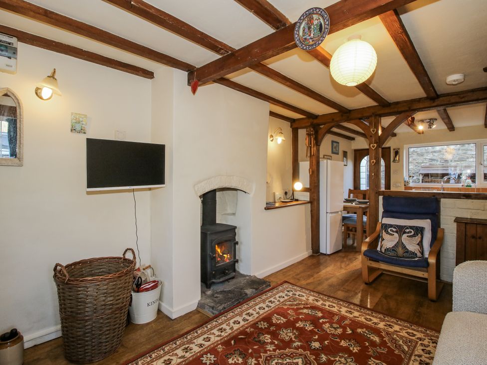 A living room with a fireplace and television at Marigold Cottage in Clun near Bishop's Castle