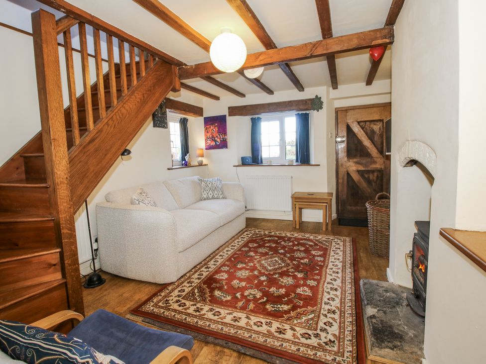 A living room with a sofa and rug at Marigold Cottage in Clun near Bishop's Castle